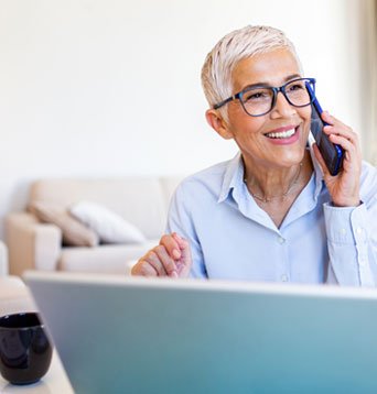 Woman on telephone with laptop voting in Port Hope